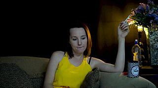 A brunette is seductively sucking on a cigarette while she is staring at you