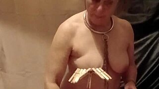 female slave in bdsm self-session with clamps and piss