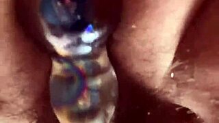 Solo hairy beaver glass dildo close up.