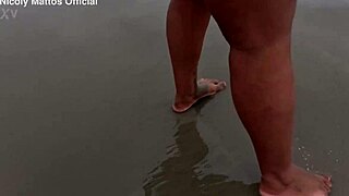 hot girl walks barefoot on beach with dirty feet soles. she shows wet foot fetish play outdoors in public