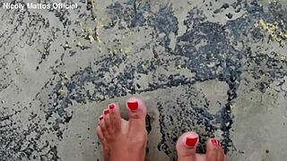 hot girl walks barefoot on beach with dirty feet soles. she shows wet foot fetish play outdoors in public