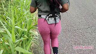 ebony with big ass in leggings runs alone in nature, showing off tattoo and prostitute vibe boldly.