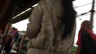 In the crowded train setting, a woman sports a casual jacket and sturdy boots during her daily commute. Part 1.