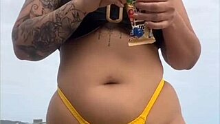 young african girl on usa beach wears tight yellow bikini to show swollen pussy and draw attention