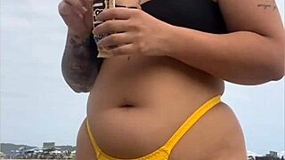 young african girl on usa beach wears tight yellow bikini to show swollen pussy and draw attention