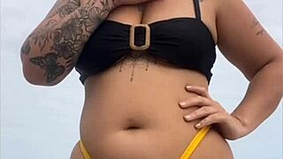 young african girl on usa beach wears tight yellow bikini to show swollen pussy and draw attention