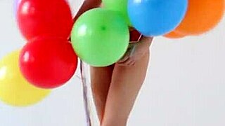 teen girl strips nude playing with balloons in the room