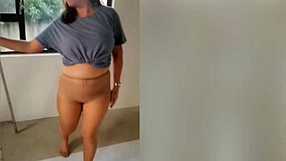 Schnaz, a milf with big breasts, models black and tan pantyhose in solo video