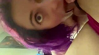 the purple haired girl performs a blowjob on the cock